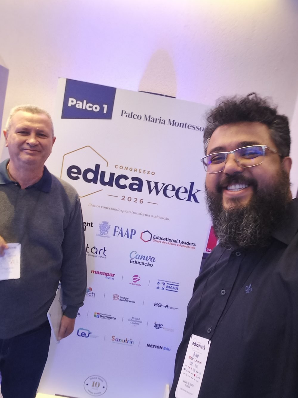Selfie de Tio Rafa e um colega diante do painel do Palco Maria Montessori no Educa Week 2026