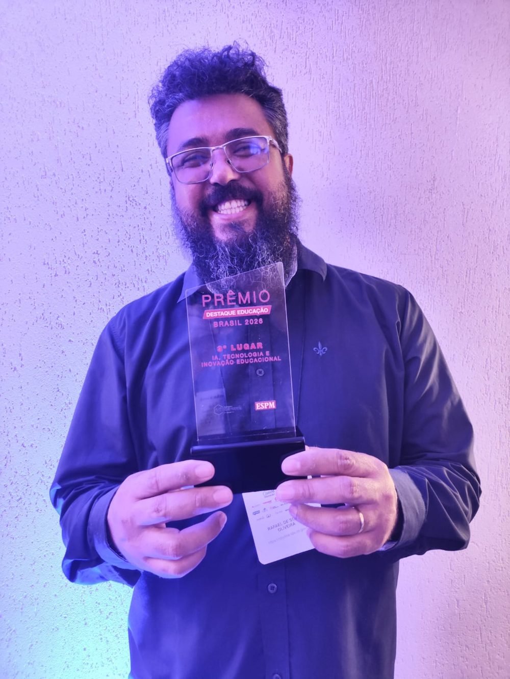 Tio Rafa segurando o troféu de 3º lugar na categoria IA, Tecnologia e Inovação Educacional do Prêmio Destaque Educação Brasil 2026